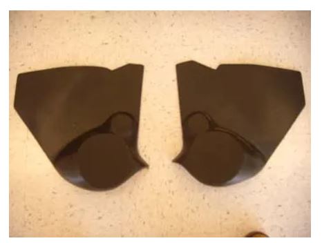 Two dark brown plastic parts on a light-colored surface.